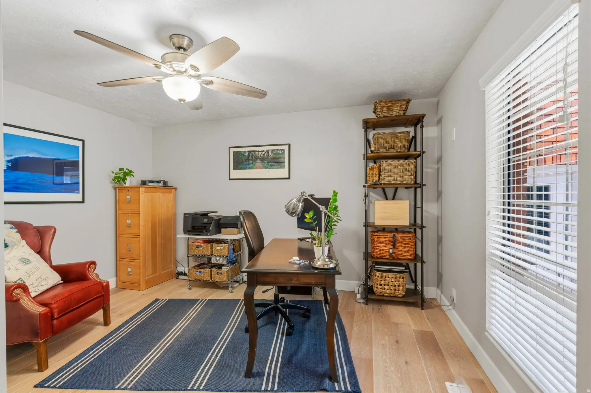 Bedroom/Office featuring white oak flooring, double-door closet, a ceiling fan with integrated lighting, and lots of natural light