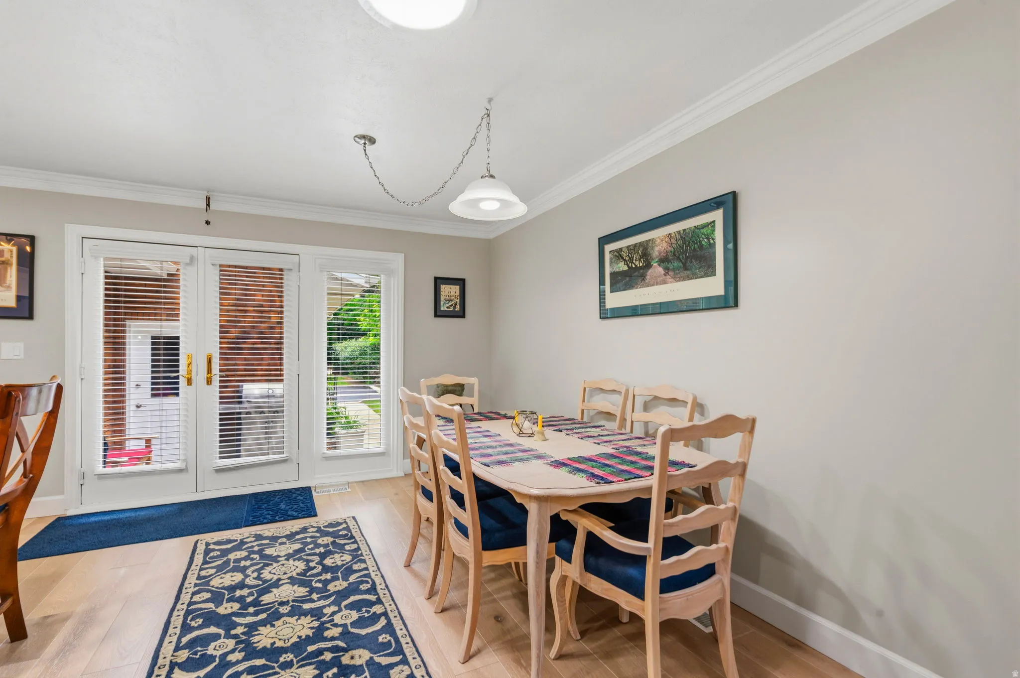 Dining area featuring white oak flooring, Anderson Atrium French doors with 2" horizontal cordless blinds providing direct access to patio area and crown molding
