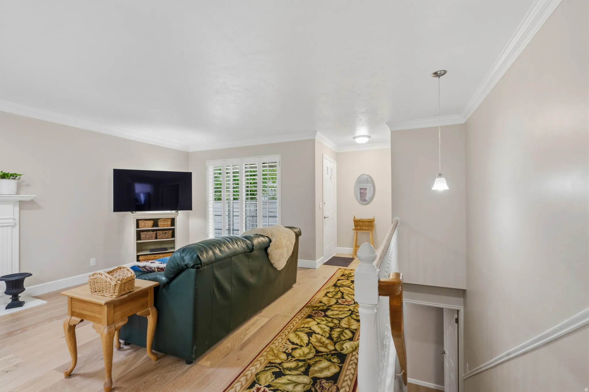 Spacious living area featuring white oak flooring, two-tone paint, solar tubes, lots of natural light, gas log fireplace, plantation shutters and crown molding
