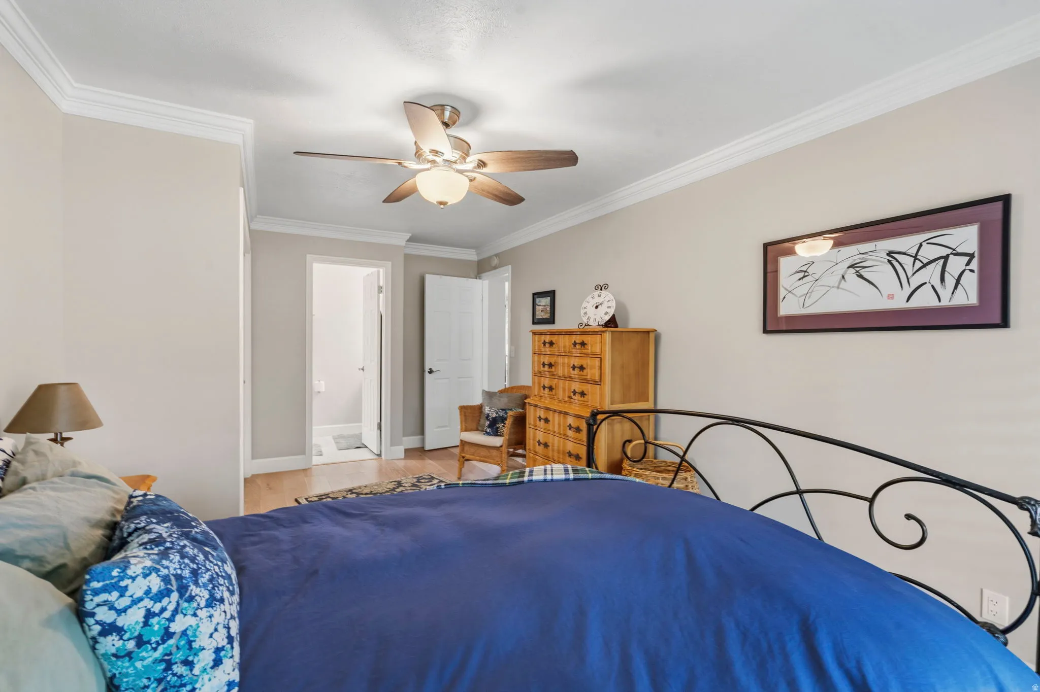 White oak flooring complements the room's two-tone paint with lots of natural light, ceiling fan, plantation shutters, crown molding and private full bath.