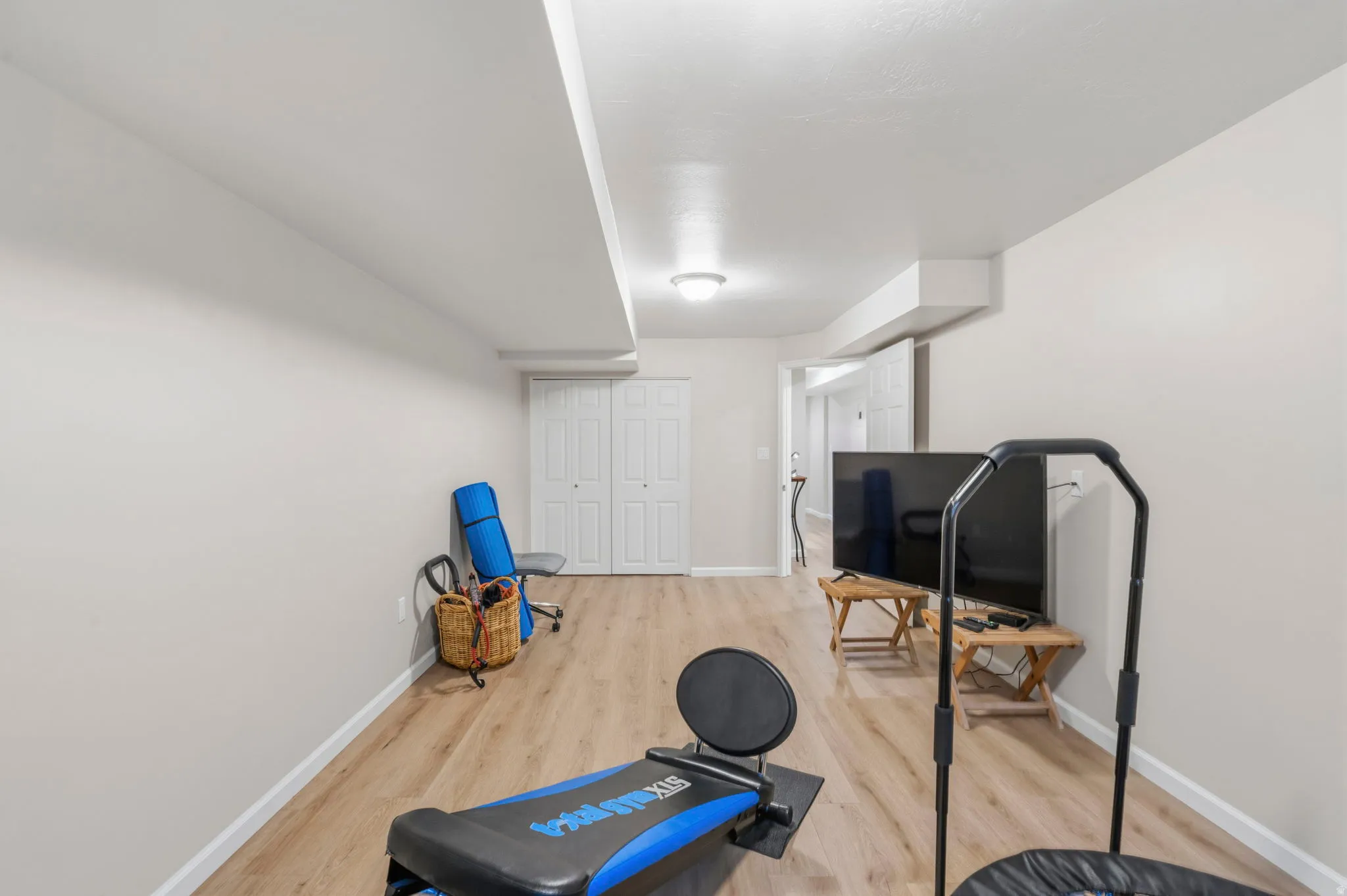 Bedroom/Exercise room featuring LVP flooring, two-tone paint, two-door closet with extra inside shelving, lots of natural light