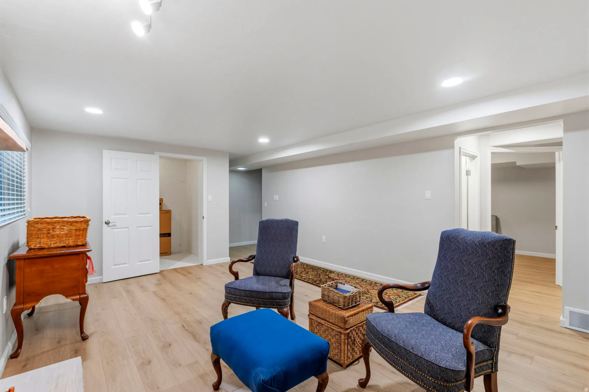 Spacious living area featuring LVP flooring, recessed lighting, and a stone-surround gas log fireplace with a stone mantel