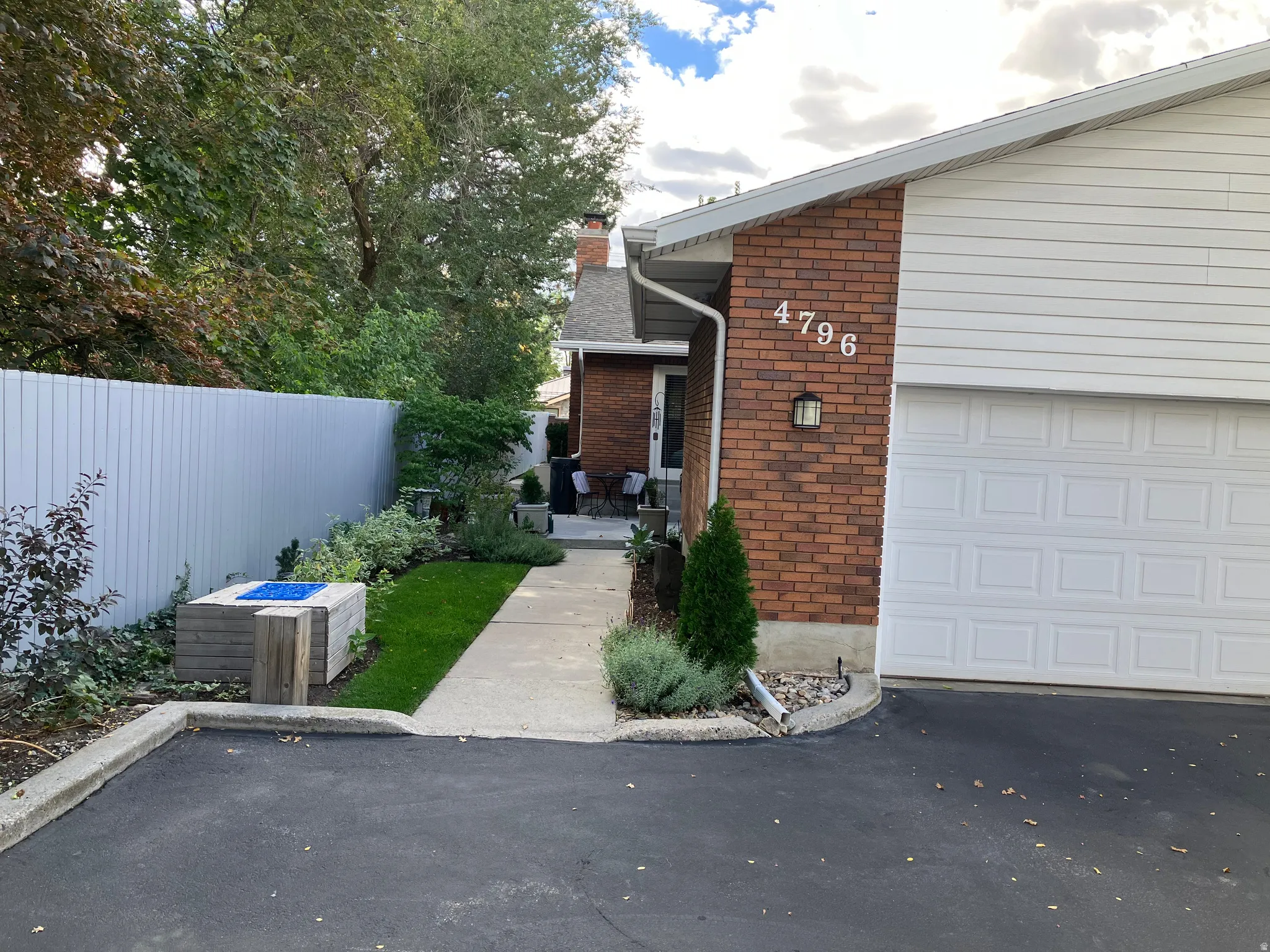 Brick and aluminum siding exterior with attached garage featuring garage door opener and keypad entry.