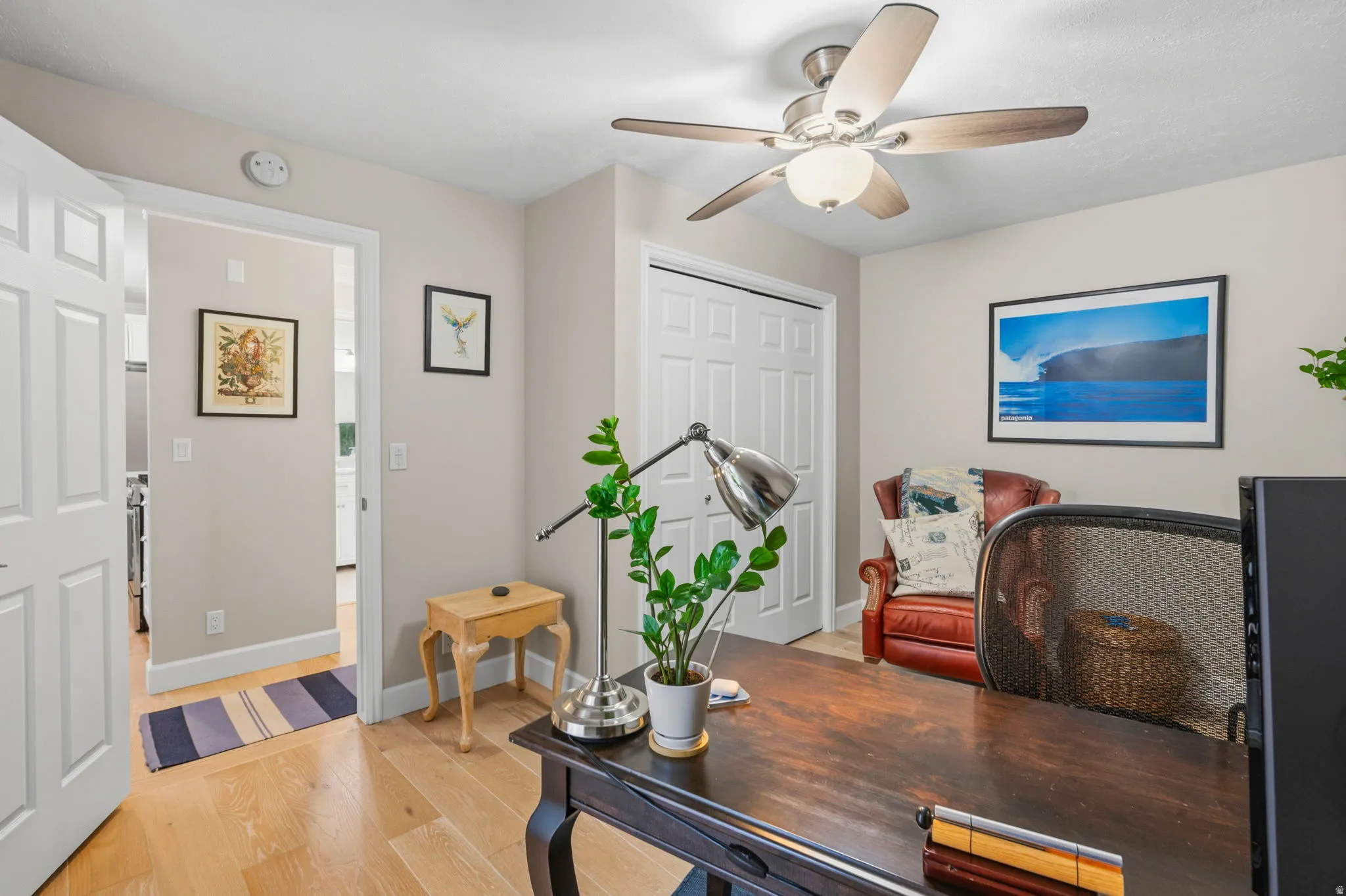 Bedroom/Office featuring white oak flooring, double-door closet, a ceiling fan with integrated lighting, and lots of natural light