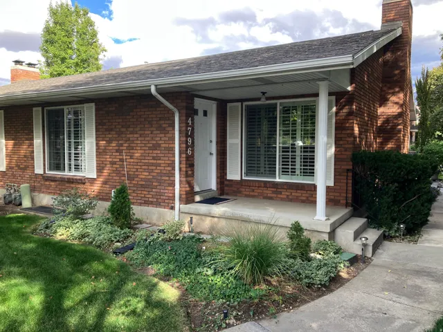 Brick exterior featuring a covered porch entry, perfect for enjoying evening sunsets.  Rare end-unit ranch-style condo (duplex).