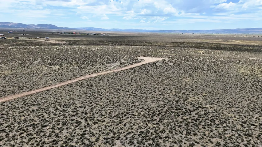 Expansive desert landscape featuring a prominent dirt access road