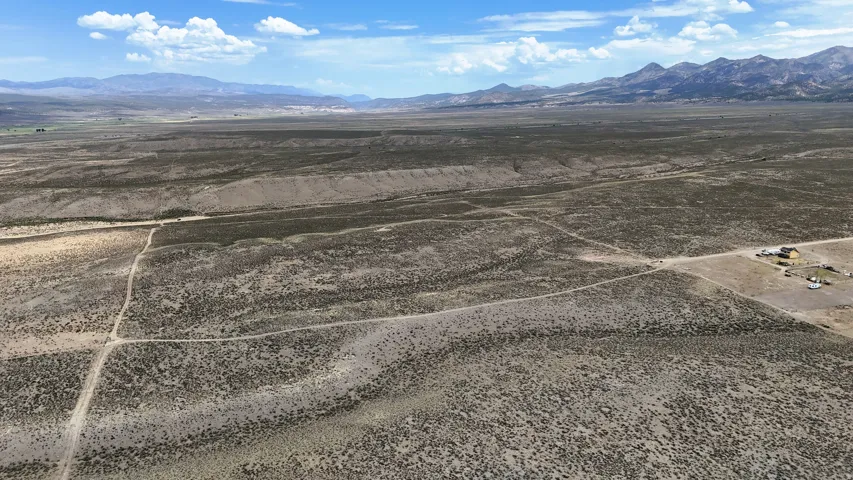 Expansive arid landscape featuring natural vegetation and distant mountain ranges