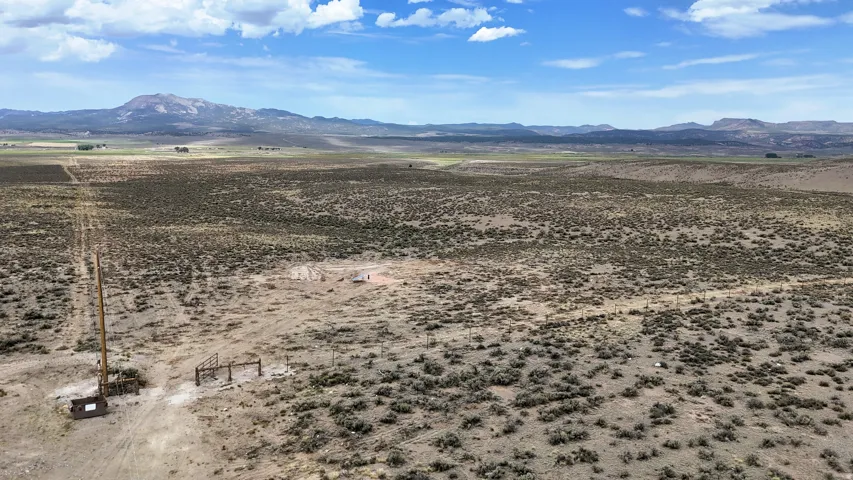 Expansive undeveloped terrain featuring natural vegetation and distant mountain ranges