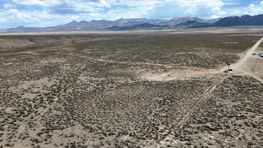 Expansive desert landscape featuring natural scrubland vegetation and distant mountain ranges