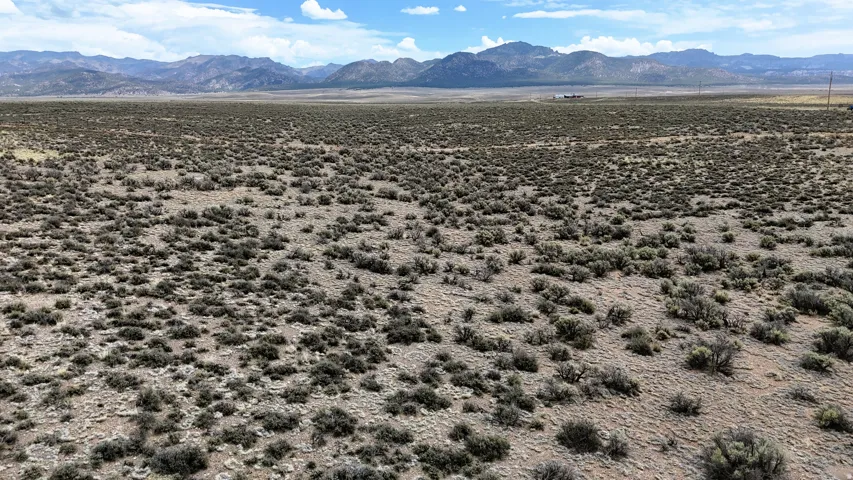 Expansive undeveloped land featuring natural desert vegetation and distant mountain ranges