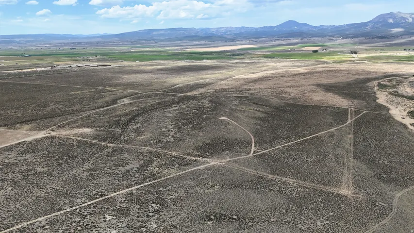 Expansive undeveloped land featuring natural terrain and distant mountains