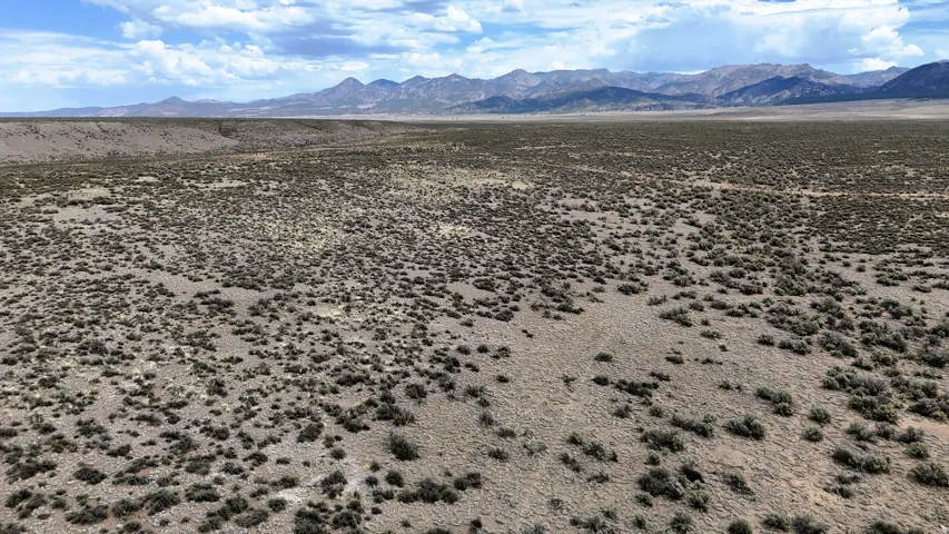 Expansive desert landscape featuring rugged terrain and distant mountains