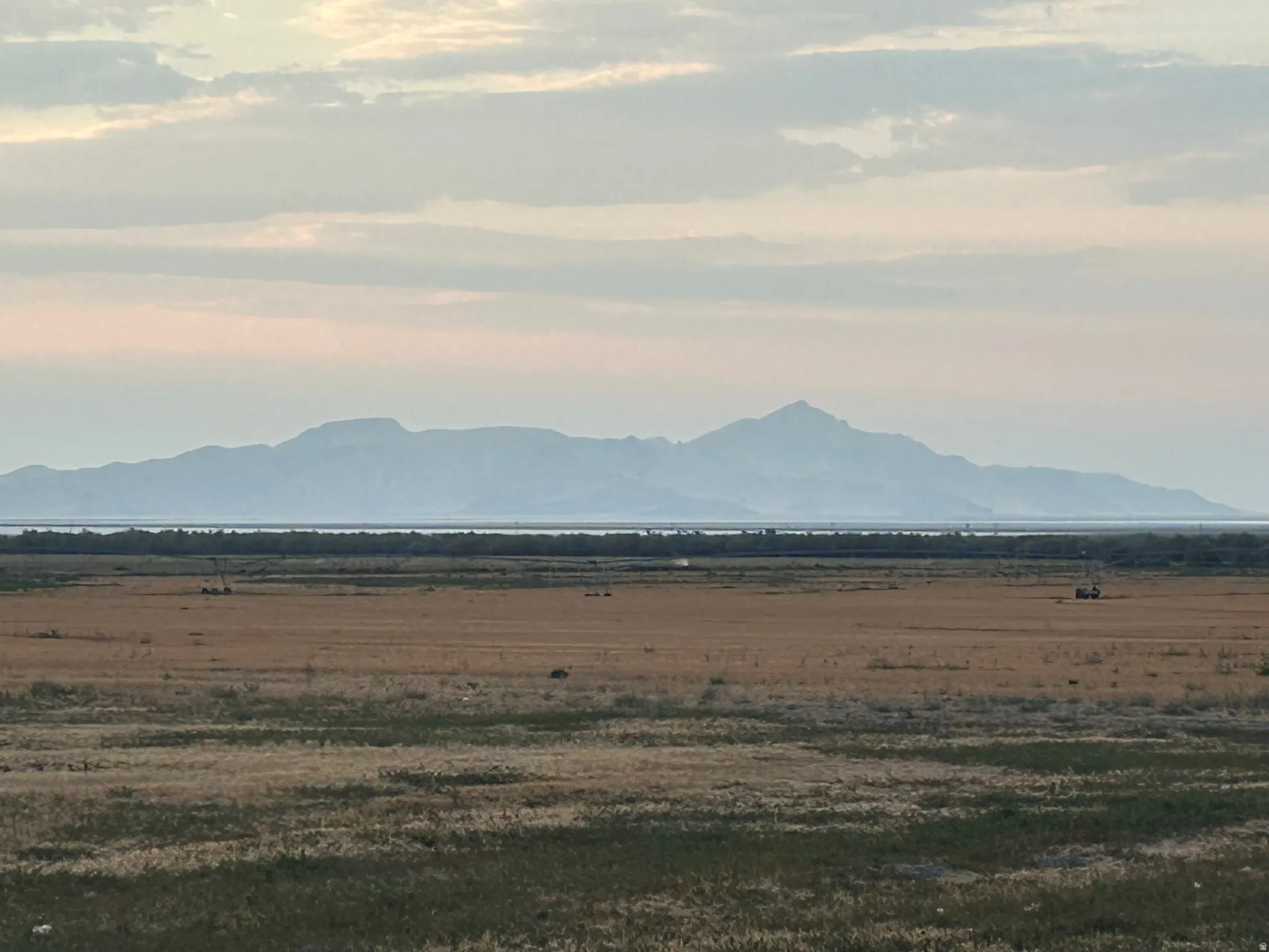 Expansive land area featuring natural vegetation and distant mountains