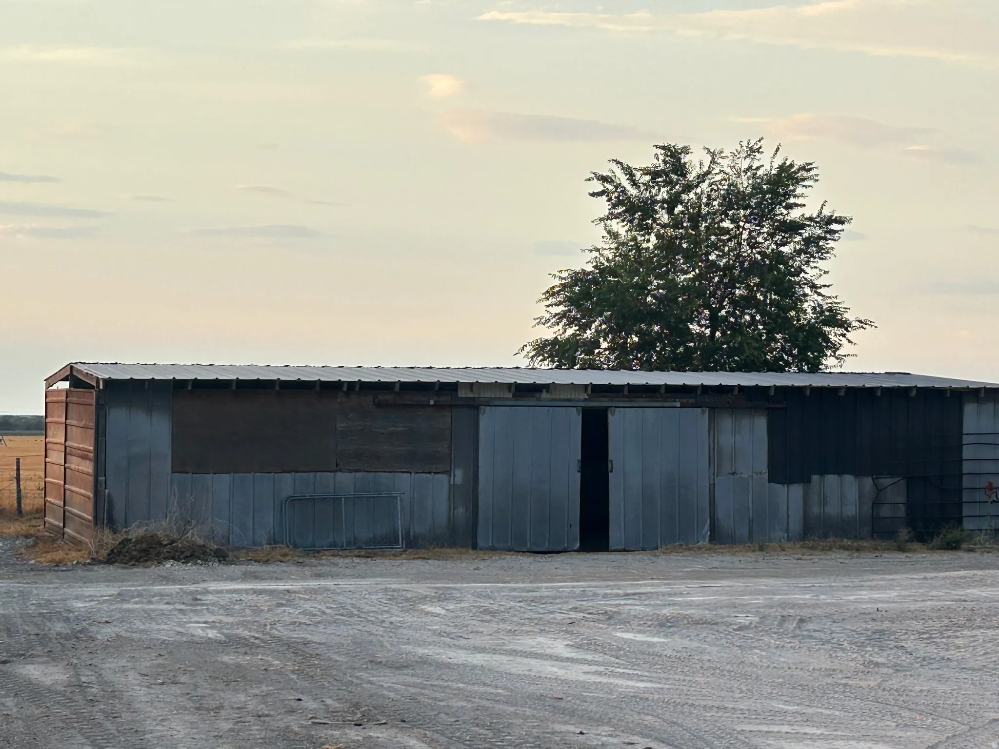 Metal-sided outbuilding featuring a corrugated metal roof and two large sliding doors