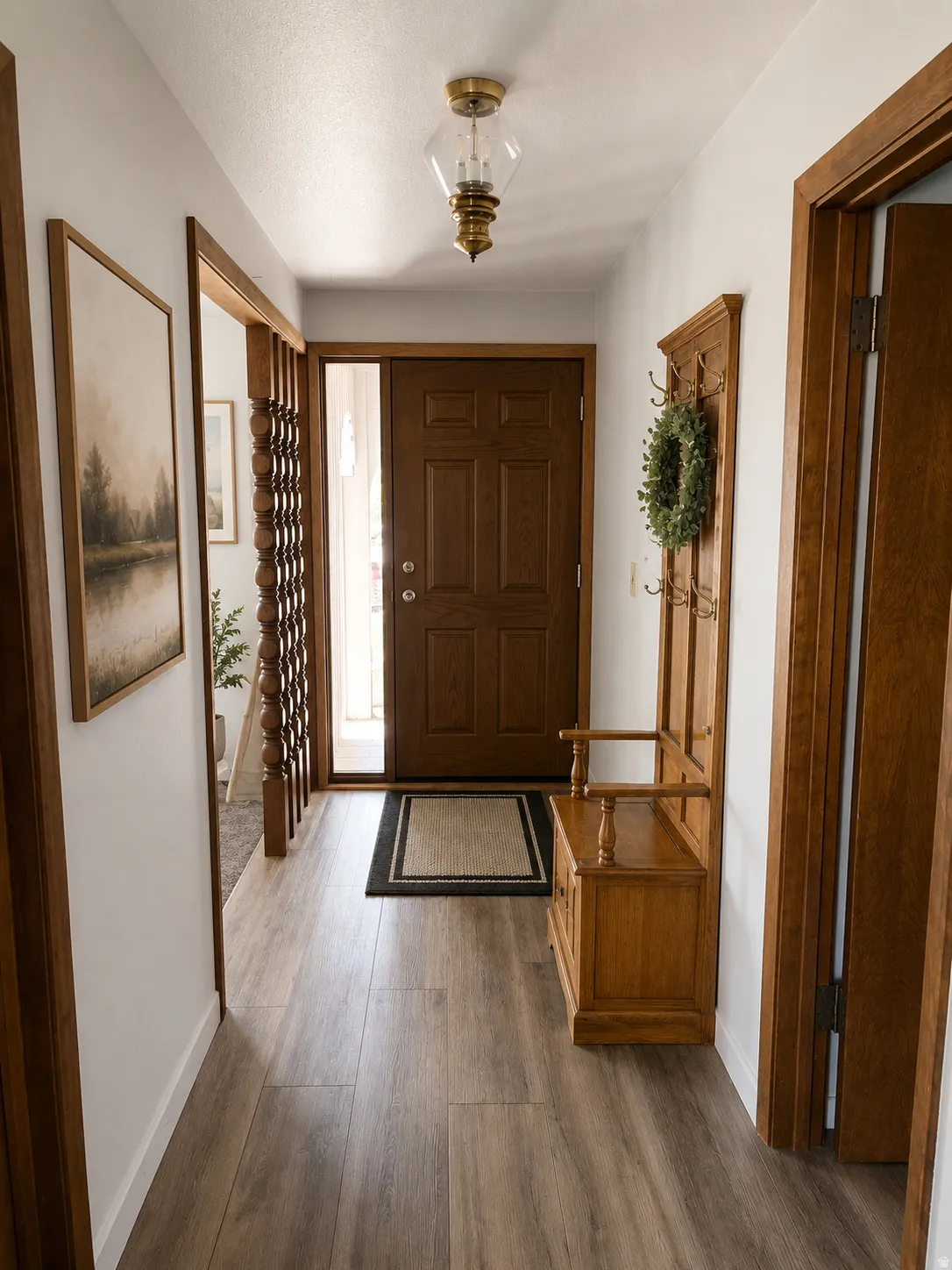Entryway featuring wood-finish flooring, a solid wood entry door with sidelight, and a brass-tone ceiling light fixture