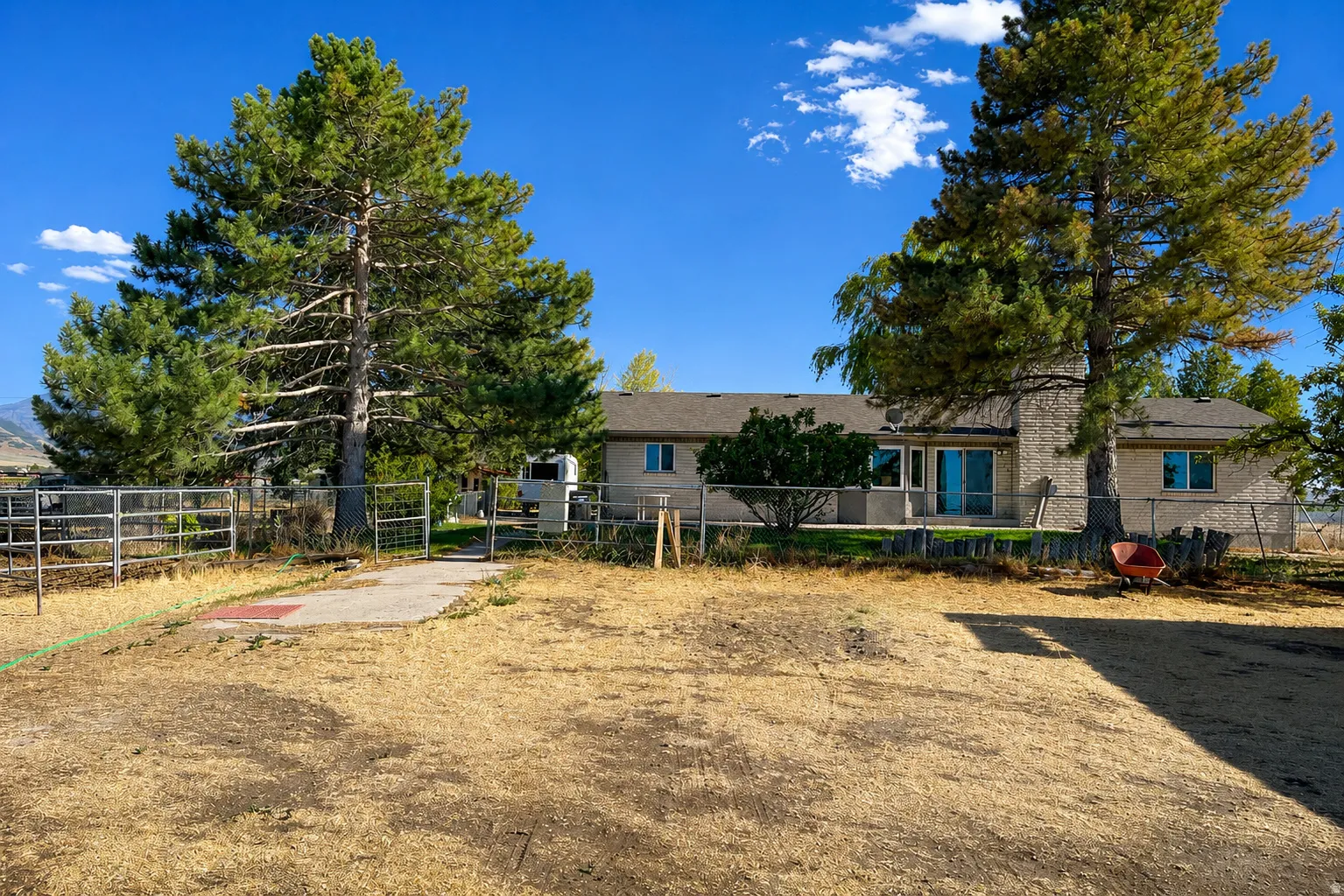 Single-story residence with a stone-clad chimney and a rear patio