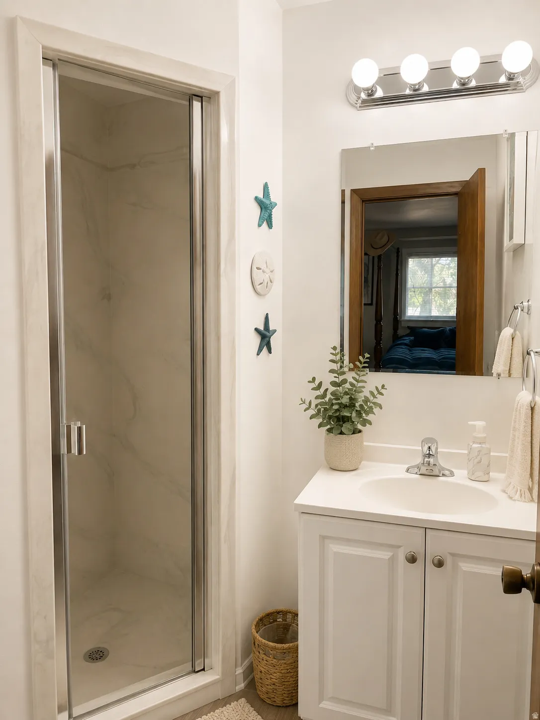 Shower with a clear glass enclosure, white vanity with paneled doors, integrated sink, and chrome fixtures