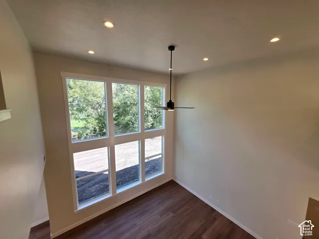 Two-story wall of windows, recessed ceiling lighting, wood-finish flooring, and a contemporary ceiling fan