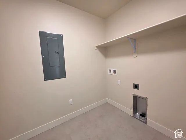 Utility space featuring a wall-mounted electrical panel, integrated shelving, and dedicated appliance hookups