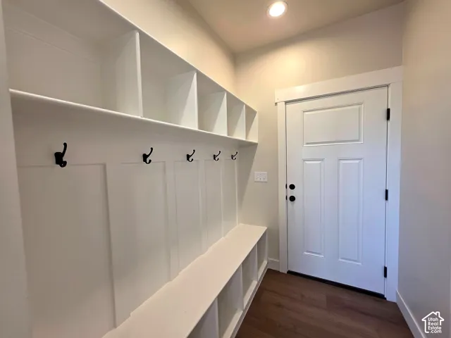 Built-in mudroom bench with cubby storage, integrated wall hooks, and overhead shelving