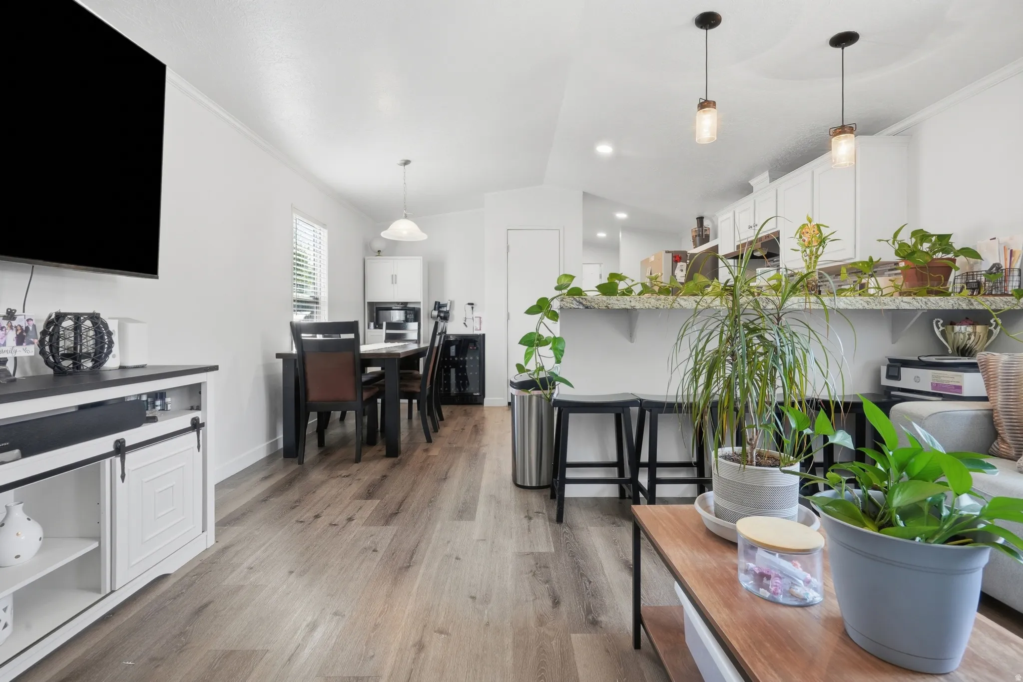 Open-concept living area featuring wood-finish flooring and white walls