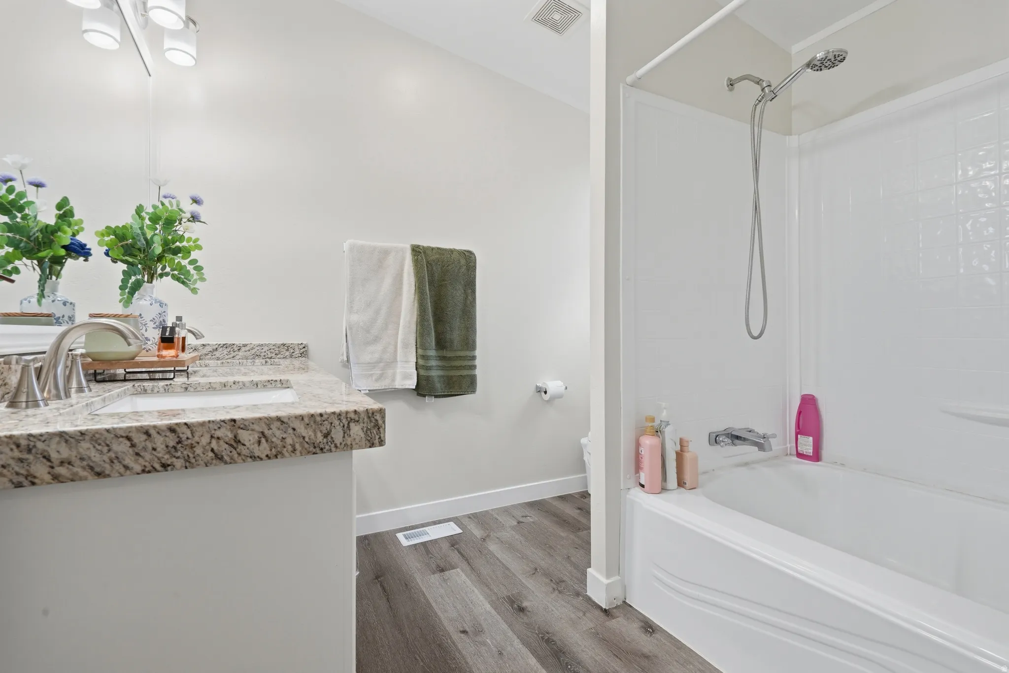 Bathroom featuring a vanity with a speckled countertop, undermount sink, and brushed nickel faucet