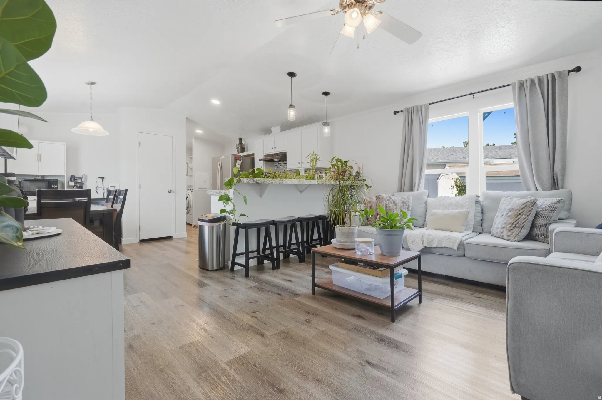 Open-concept living area featuring wood-finish flooring, recessed lighting, and a ceiling fan