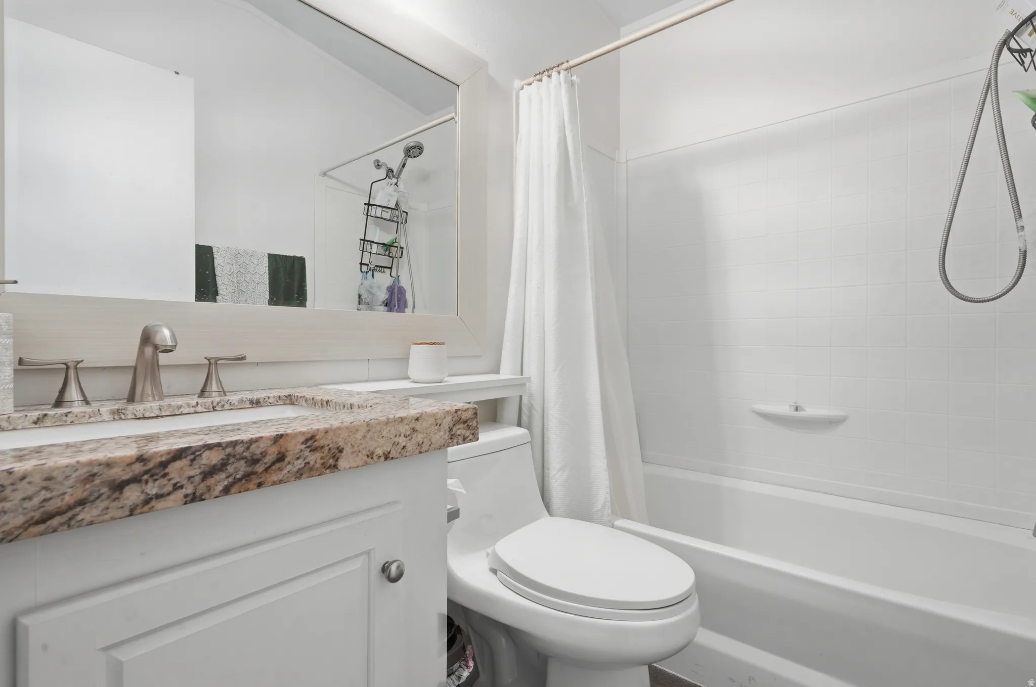 Bathroom featuring a white vanity with a patterned countertop, a built-in sink, and a brushed nickel faucet