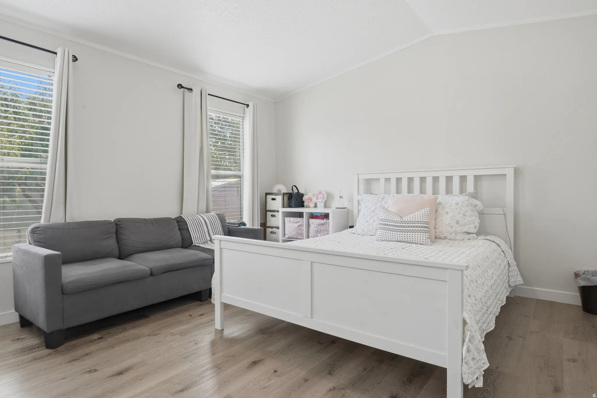 Spacious room featuring vaulted ceilings and wood-finish flooring