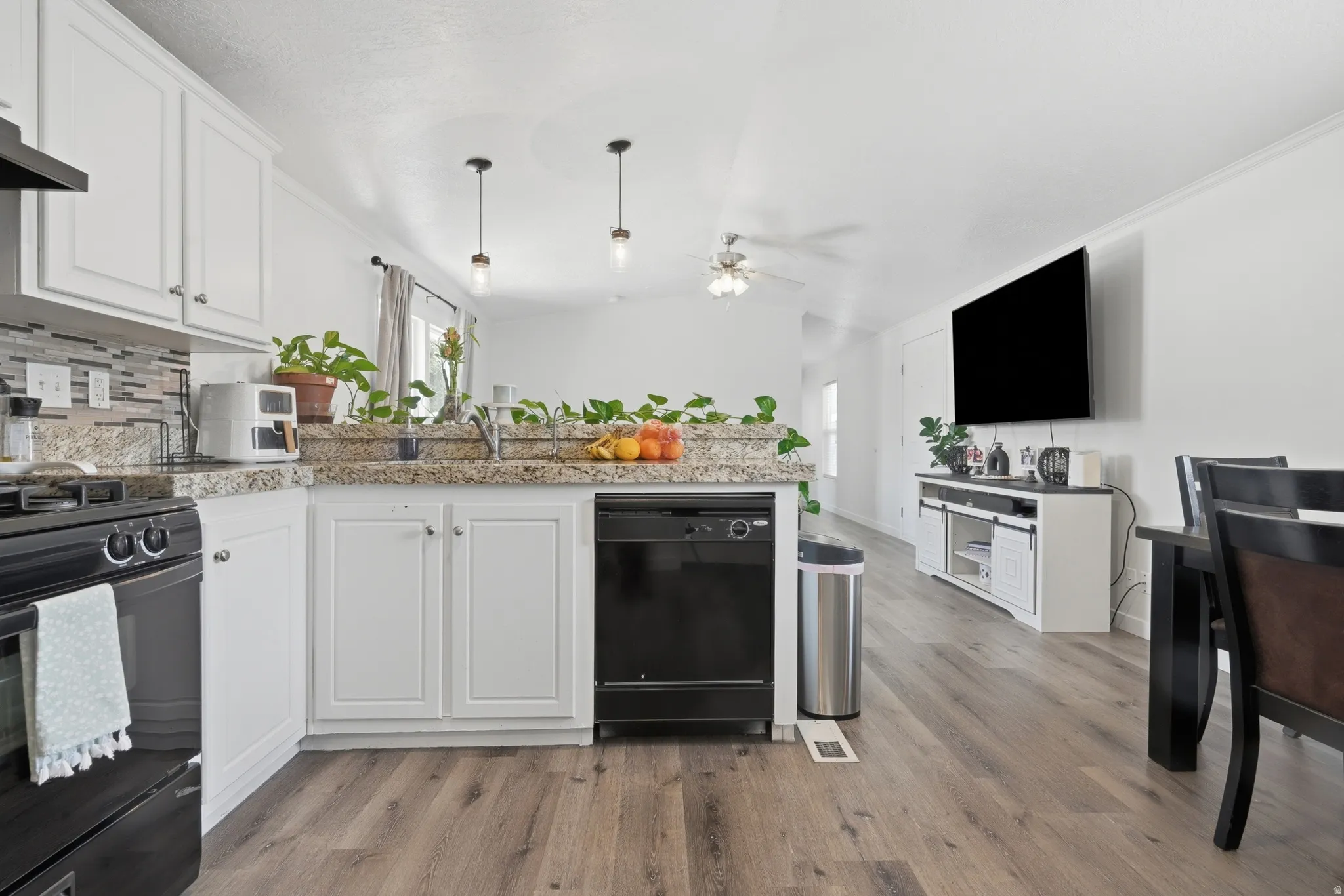 Kitchen with white cabinetry, a mosaic tile backsplash, and granite-look countertops