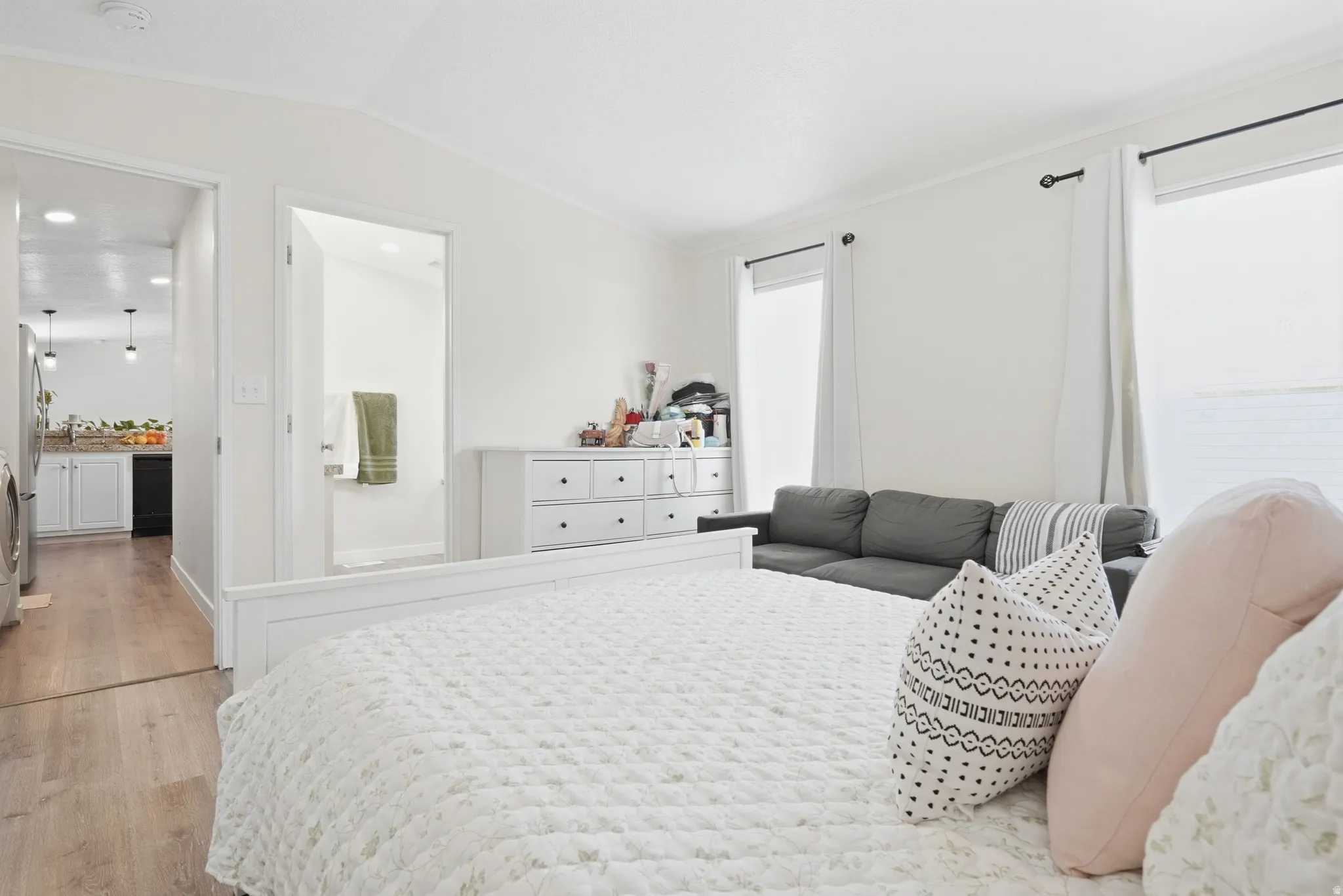 Bright room with multiple windows, wood-finish flooring, and white walls