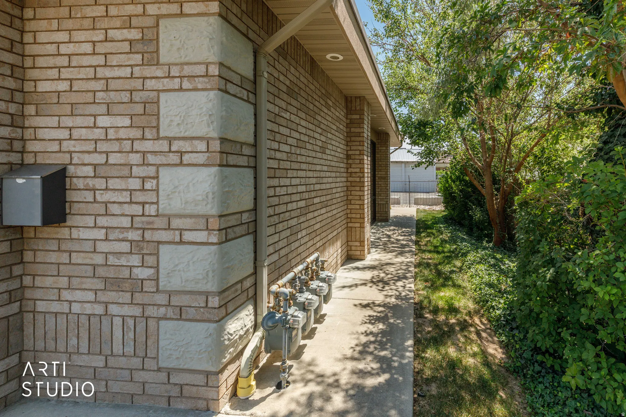Brick exterior with decorative stone accents and a concrete walkway