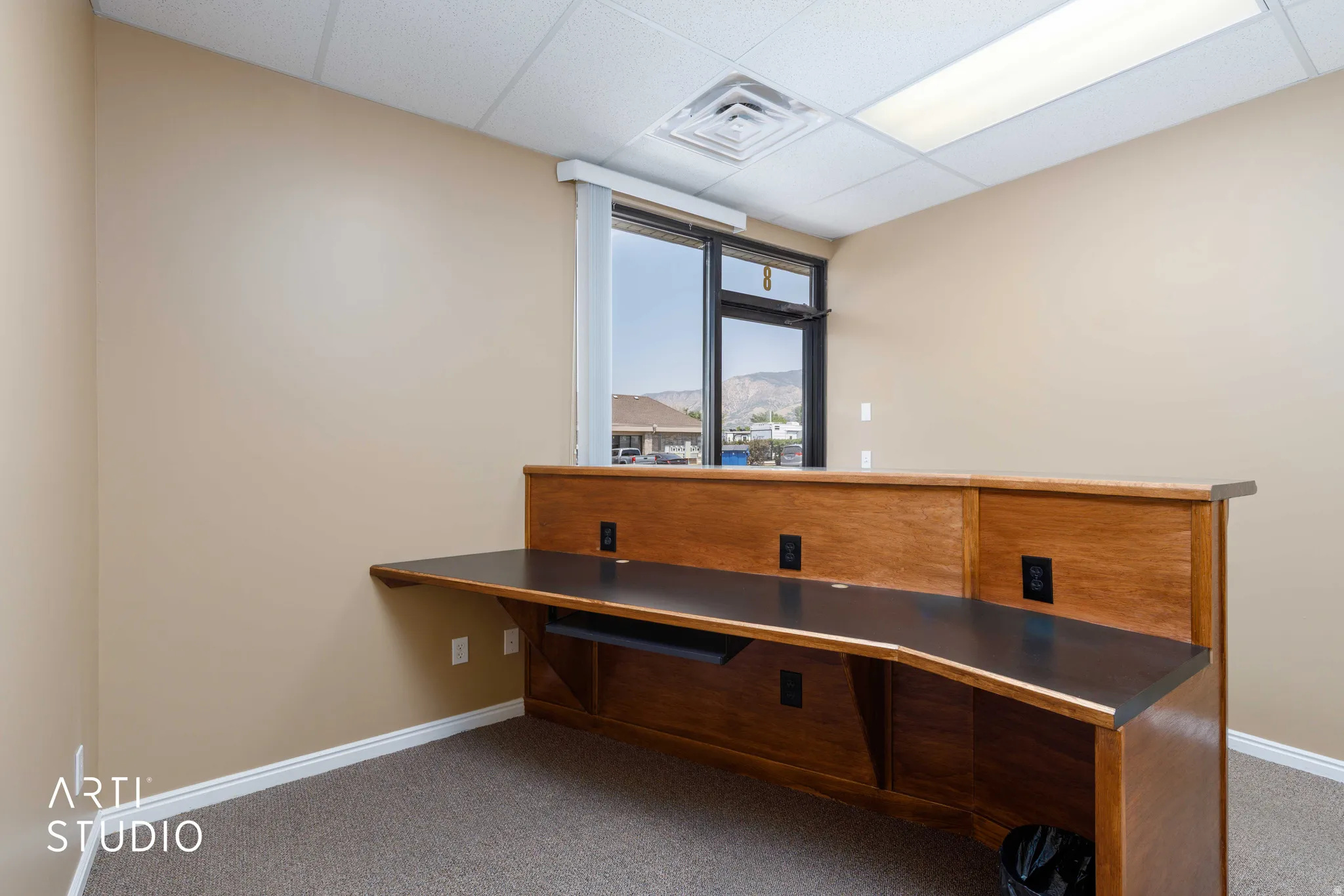 Built-in wood-finish desk with integrated power outlets, providing a functional workspace
