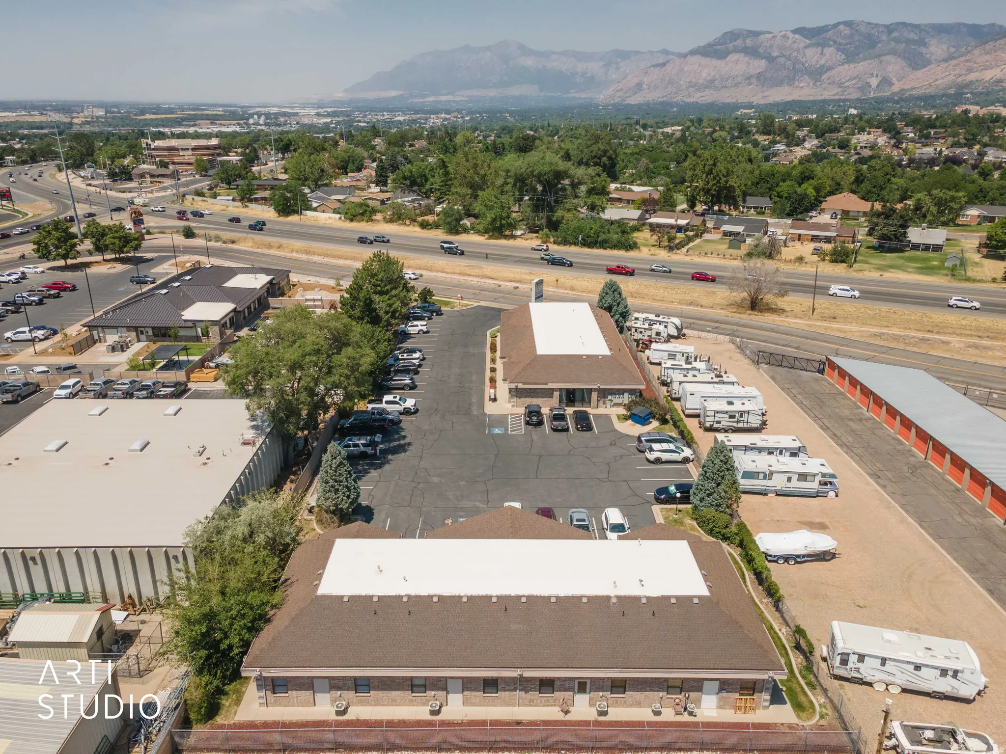 Expansive commercial property featuring multiple buildings, surface parking areas, and adjacent open-air storage