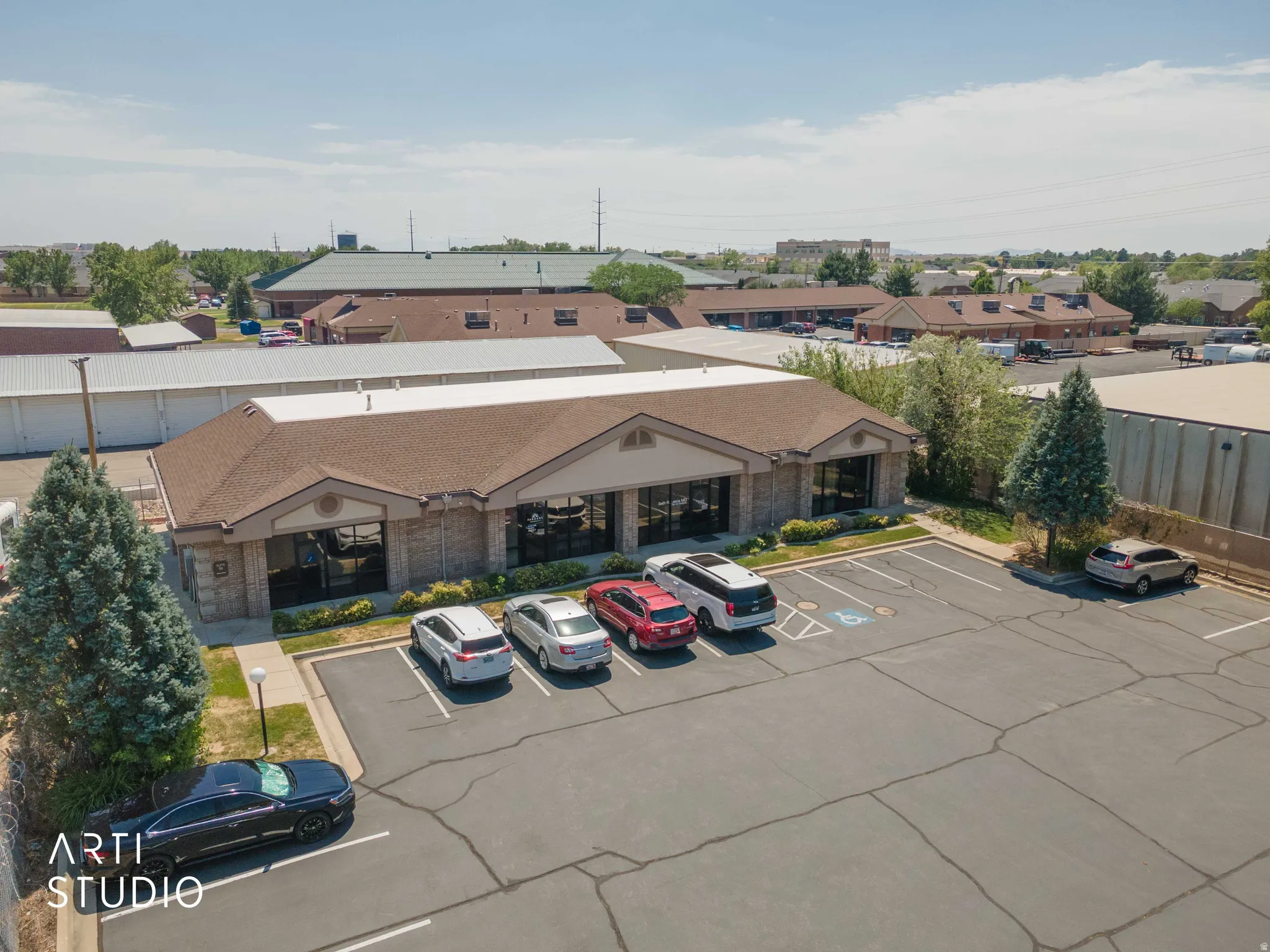 Commercial building featuring a gabled roof, brick veneer and stucco exterior, and multiple large windows
