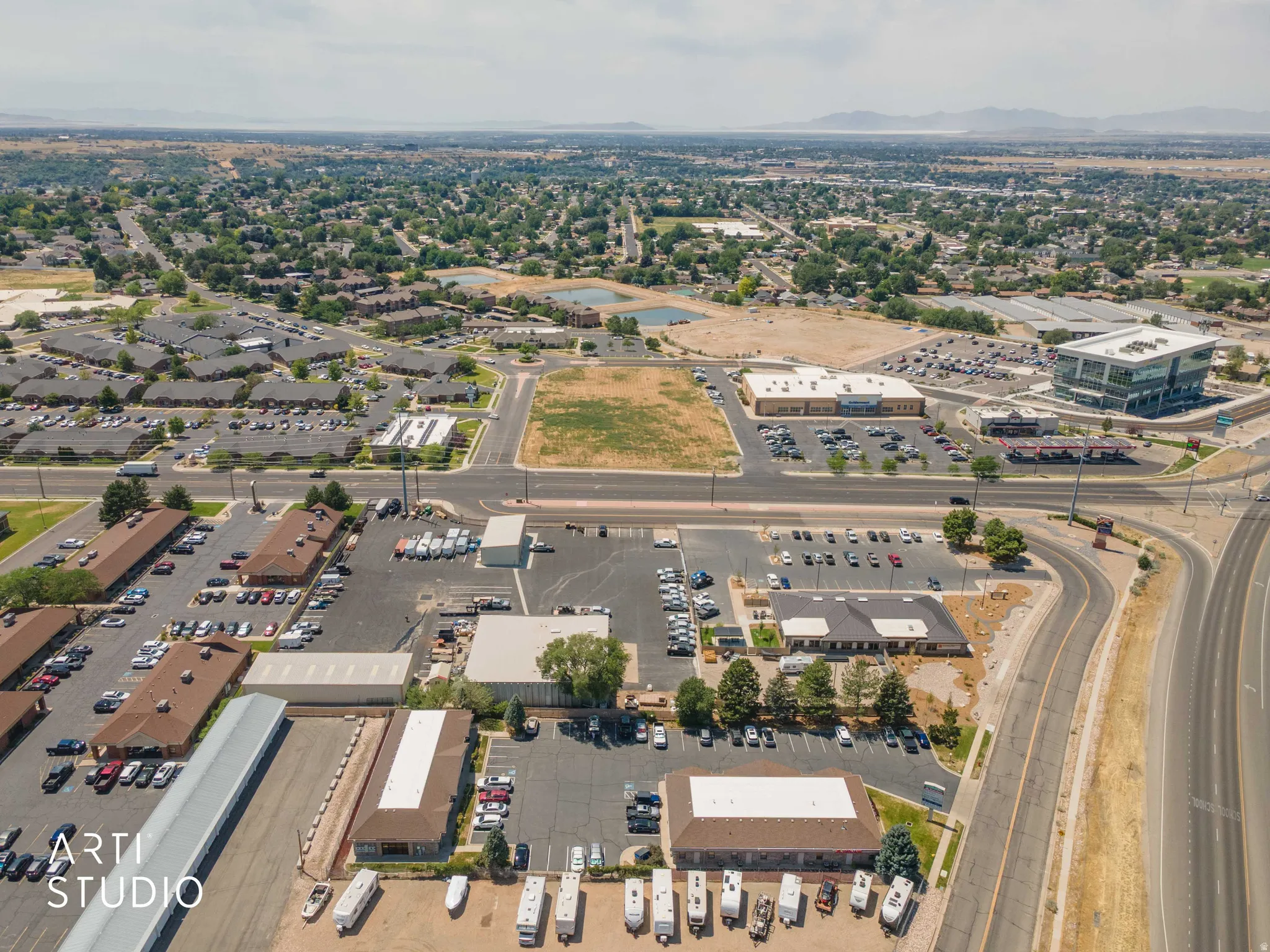 Aerial perspective showcasing a commercial property with multiple buildings and extensive paved parking areas