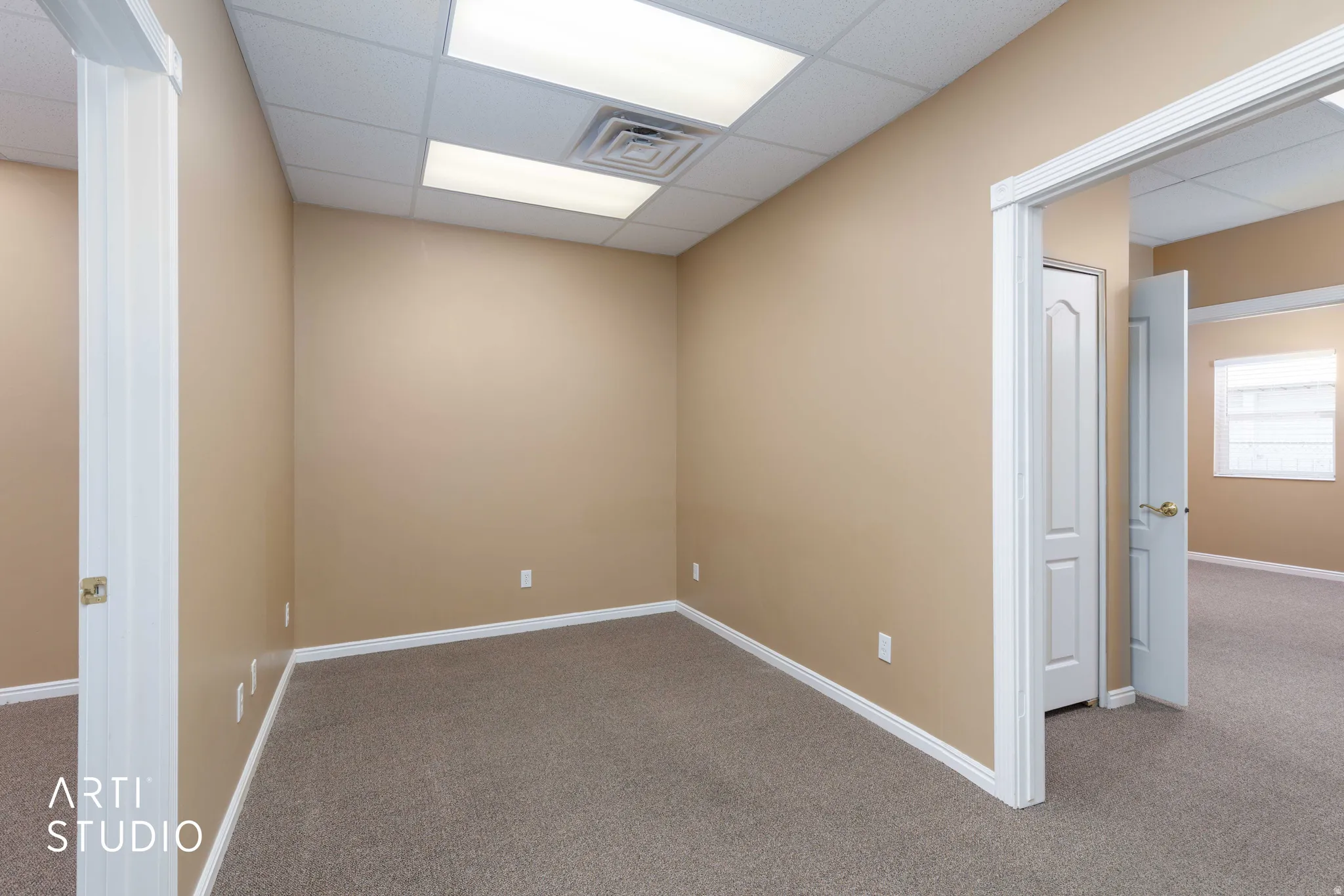 Carpeted room featuring neutral wall paint, white baseboards, and a dropped ceiling with recessed lighting