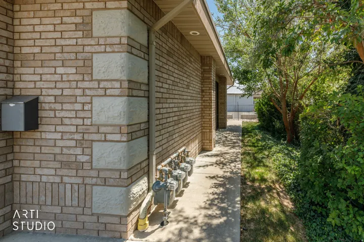 Brick exterior with decorative stone accents and a concrete walkway