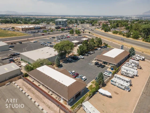Expansive commercial property featuring multiple buildings, paved parking areas, and convenient access to a main roadway