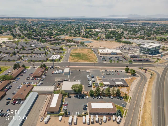 Aerial perspective showcasing a commercial property with multiple buildings and extensive paved parking areas
