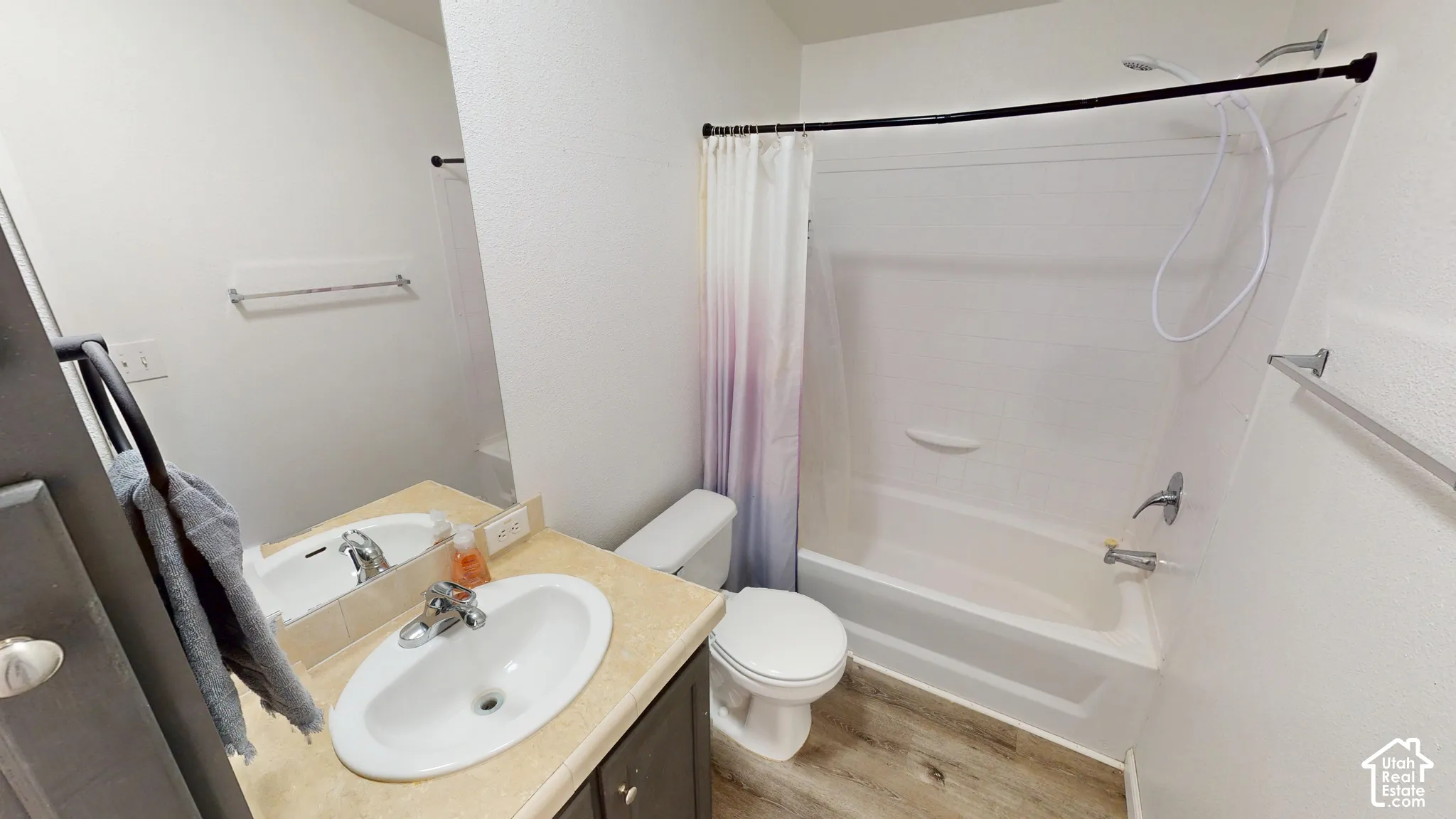 Bathroom featuring a white bathtub, toilet, and vanity with an integrated sink