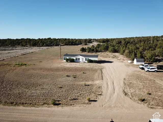 White exterior residence with a dark roofline set on an expansive, arid landscape