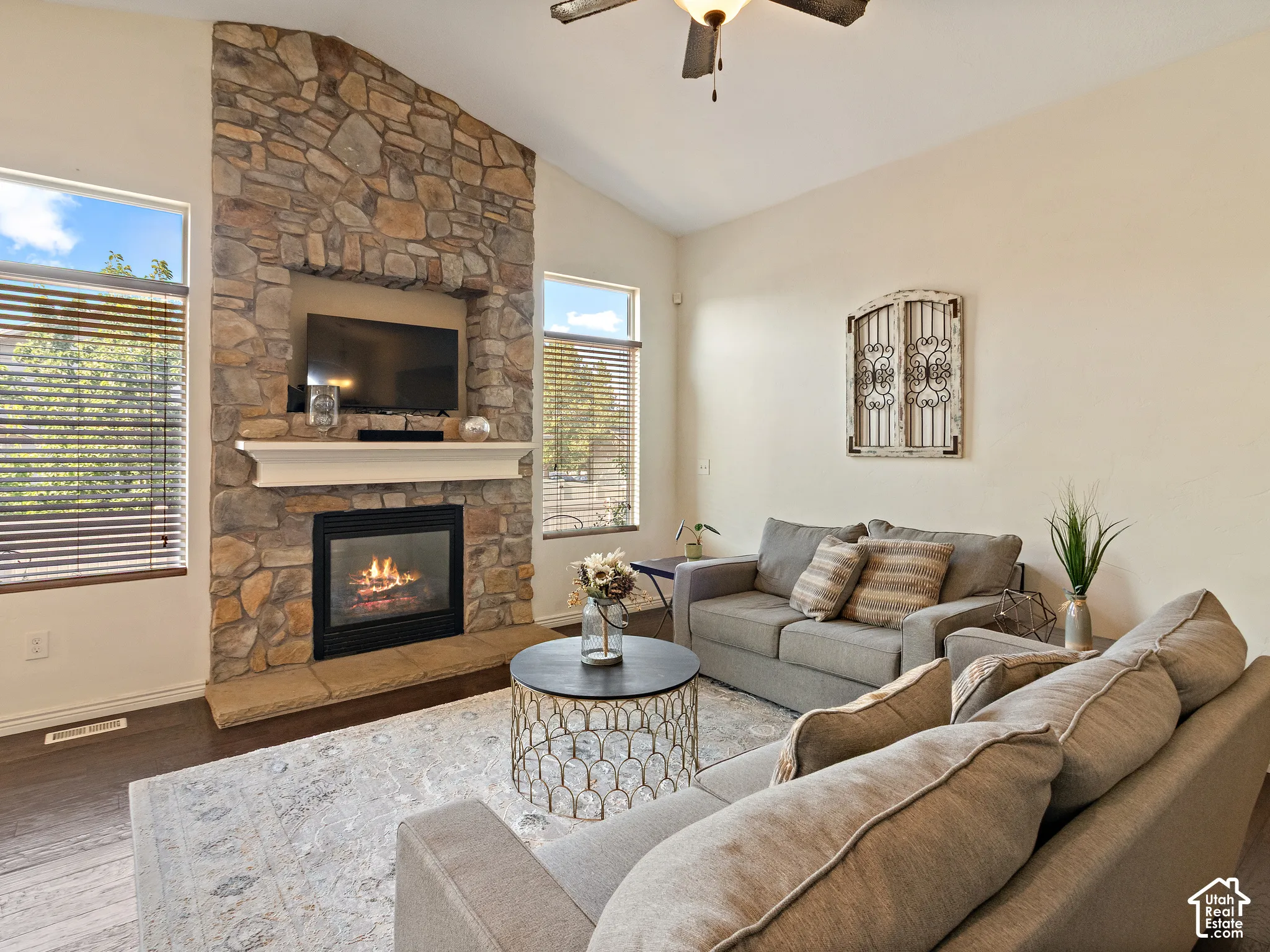 Living area featuring a floor-to-ceiling stone fireplace with a white mantel and built-in media niche