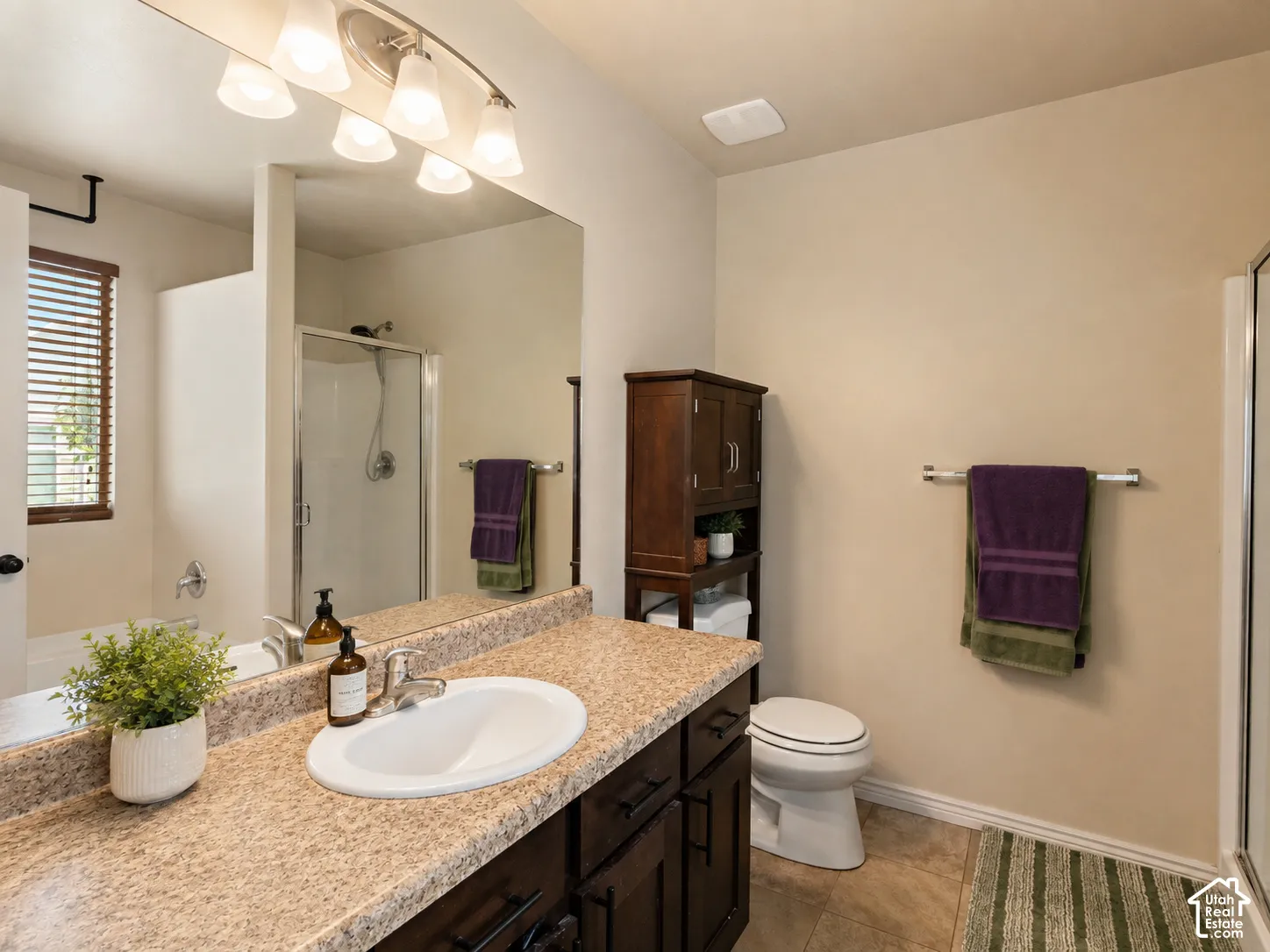 Vanity with a single basin sink, brushed nickel faucet, and a speckled countertop