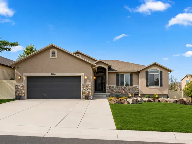 Stucco exterior with stone accents and a composition shingle roof