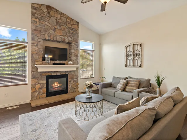 Living area featuring a floor-to-ceiling stone fireplace with a white mantel and built-in media niche