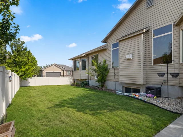 Expansive lawn area enclosed by a white privacy fence