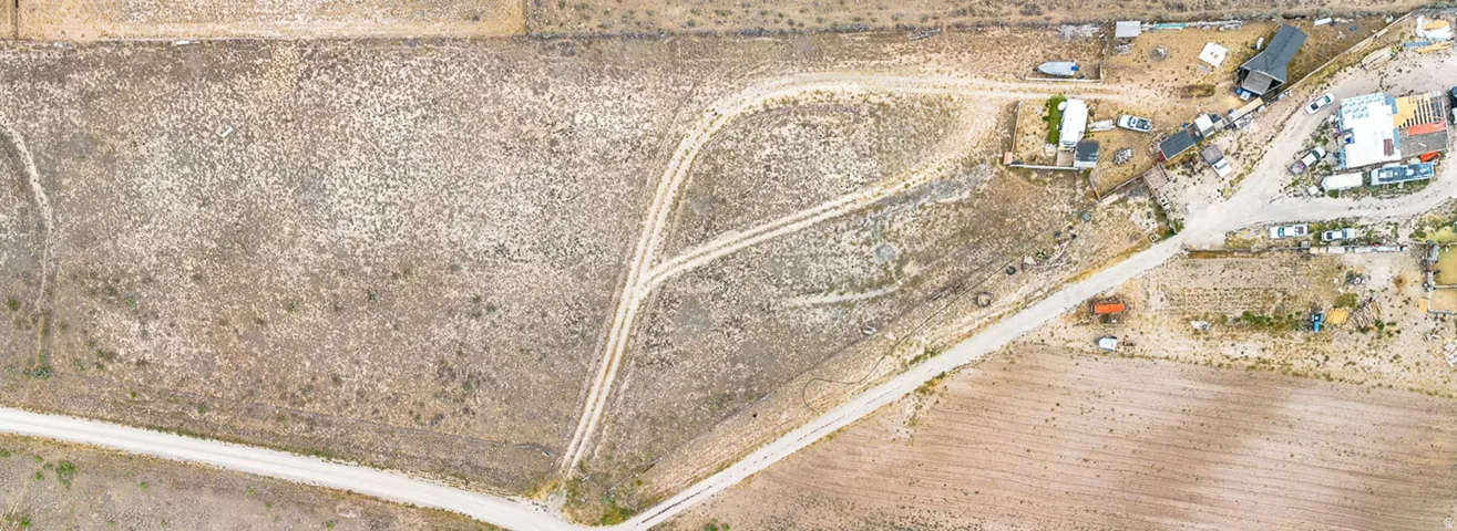 Expansive undeveloped land featuring multiple unpaved access roads and surrounding natural vegetation