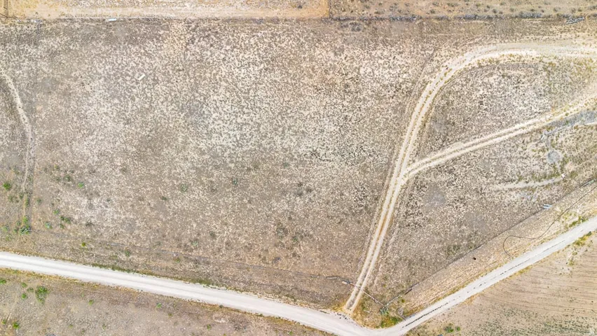 Expansive undeveloped land featuring natural terrain and visible unpaved access paths