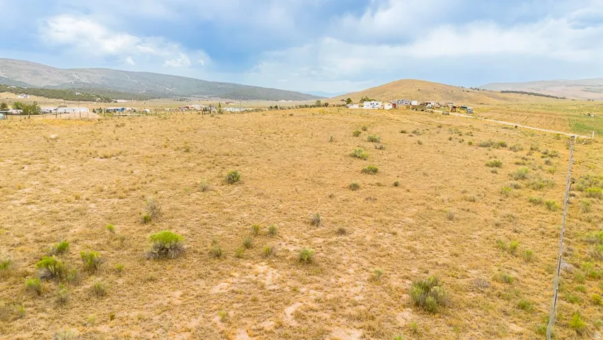 Expansive undeveloped land with dry grasses and scattered low-lying shrubs